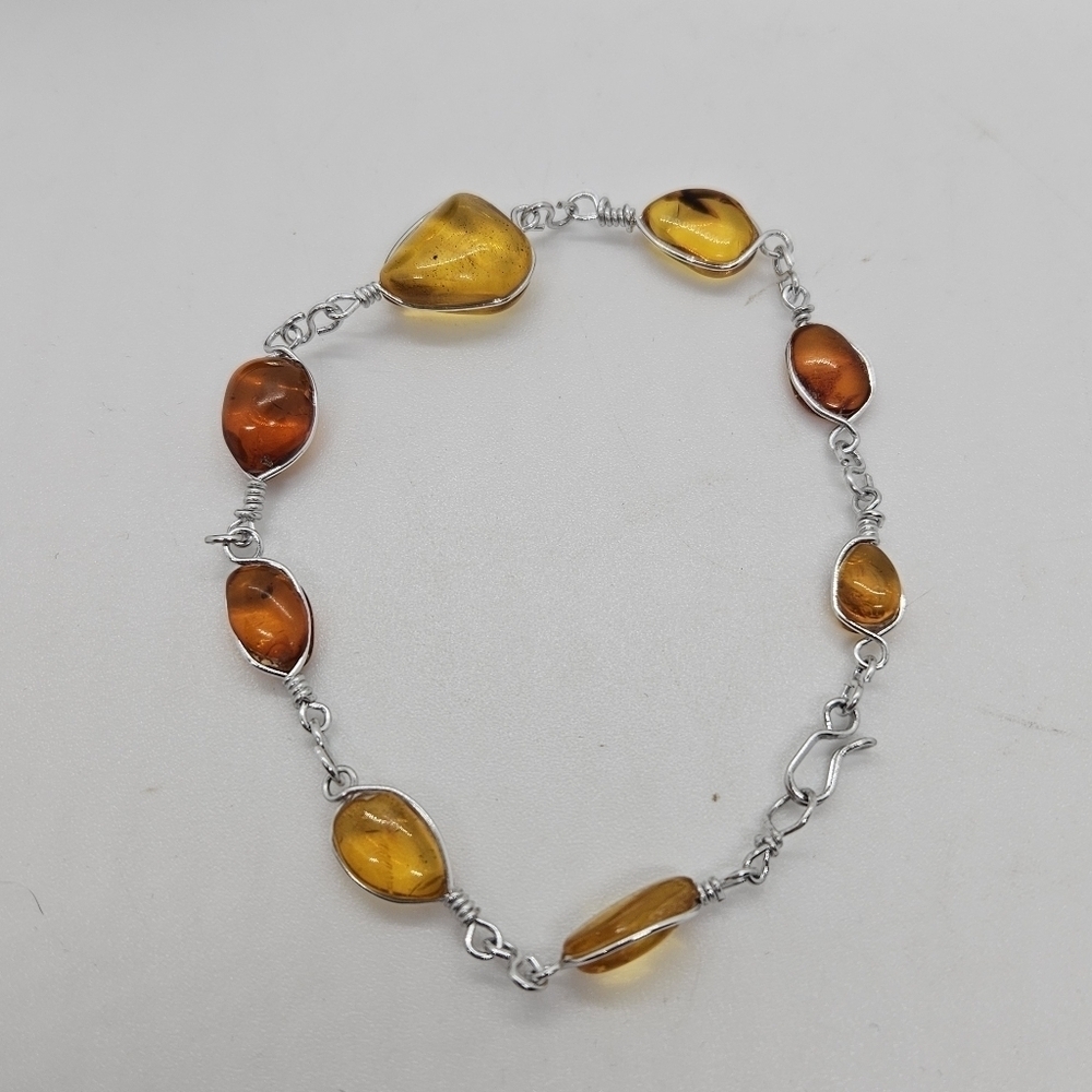 silver tone bracelet with amber colored stations
